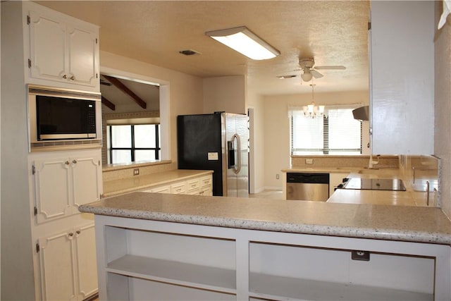 kitchen with white cabinets, a wealth of natural light, stainless steel appliances, and ceiling fan with notable chandelier