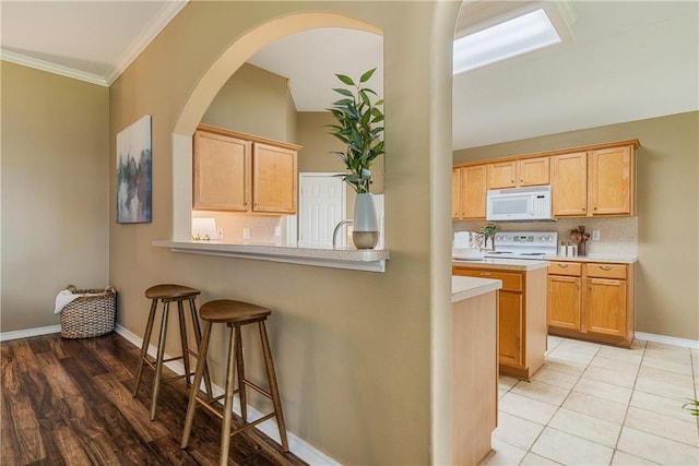 5909 Sutherland Dr, Corpus Christi, TX 78414 - kitchen featuring white appliances, a kitchen bar, light countertops, ornamental molding, and arched walkways