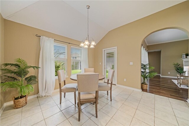 5909 Sutherland Dr, Corpus Christi, TX 78414 - dining room with arched walkways, vaulted ceiling, light tile patterned floors, and a chandelier