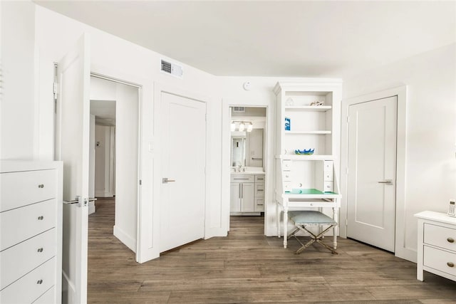 bedroom with ensuite bathroom and dark hardwood / wood-style floors