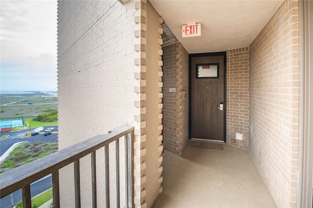 view of exterior entry featuring a balcony