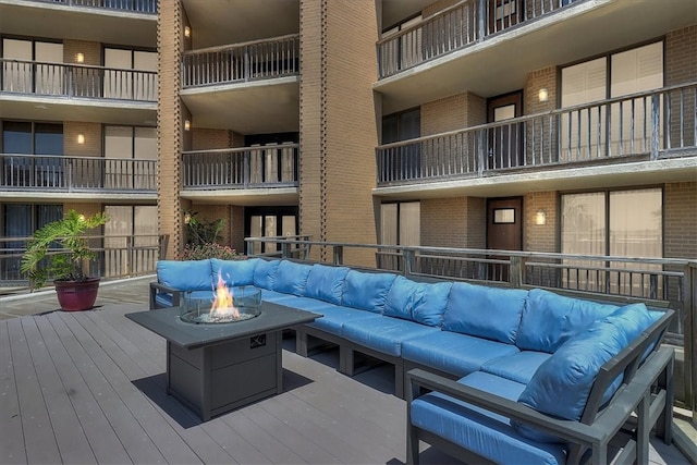 deck featuring an outdoor living space with a fire pit