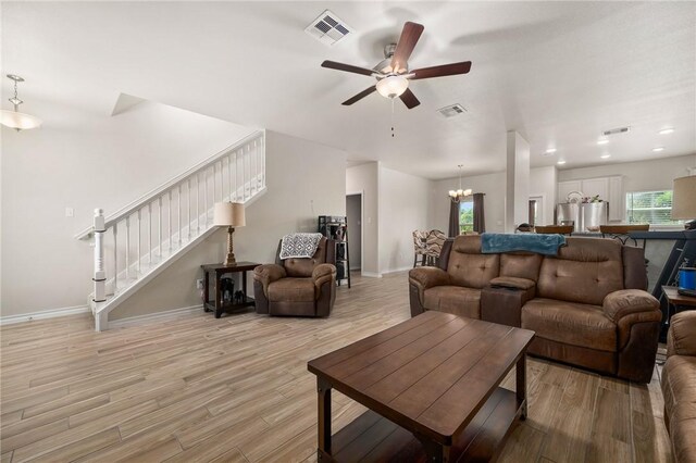 living room featuring plenty of natural light, light hardwood / wood-style floors, and ceiling fan with notable chandelier