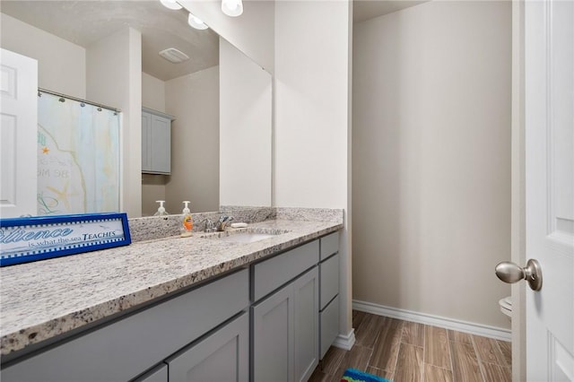 bathroom featuring wood-type flooring, vanity, and toilet