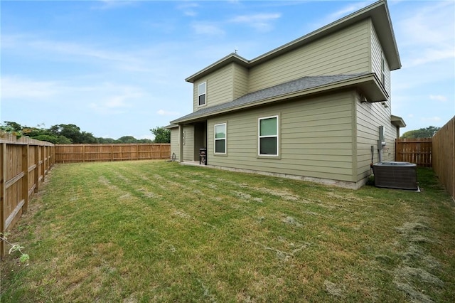 back of house with a lawn and central air condition unit