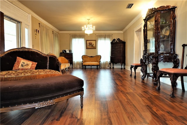 living area featuring ornamental molding, hardwood / wood-style flooring, and a chandelier