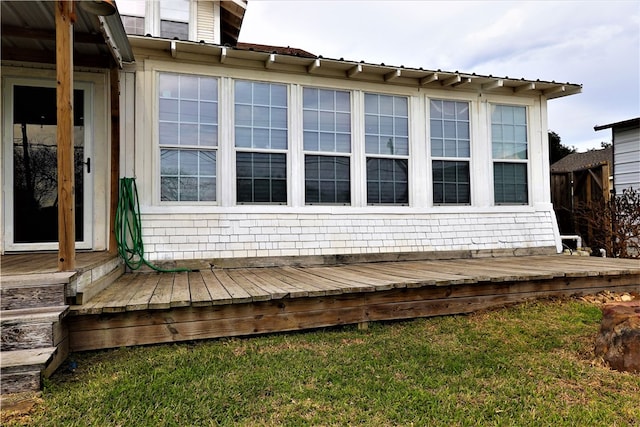 view of side of property with a lawn and a deck