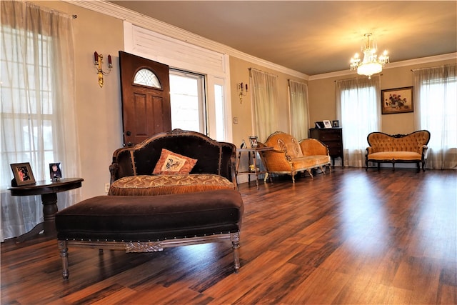 sitting room with dark wood-type flooring, a chandelier, and crown molding