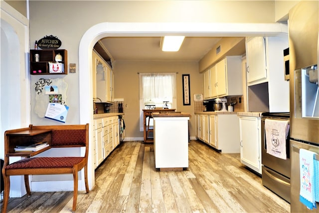 kitchen featuring white cabinetry, light wood-type flooring, and plenty of natural light