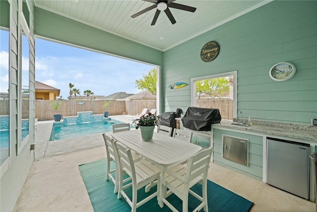 15509 Finistere St, Corpus Christi, TX 78418 - view of patio with a fenced in pool, exterior kitchen, a fenced backyard, a sink, and a grill