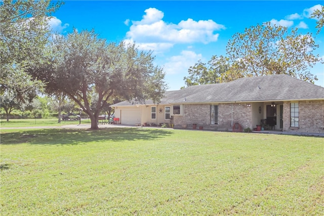 back of property with a garage and a yard