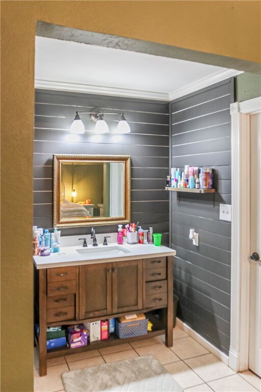 bathroom featuring vanity, tile patterned flooring, and ornamental molding