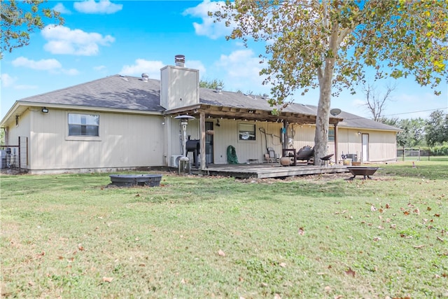 back of property featuring a lawn and a wooden deck