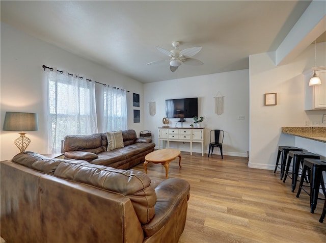 living room featuring ceiling fan and light wood-type flooring