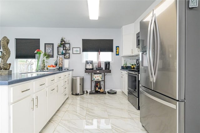 205 S 2nd St, Rockport, TX 78382 - kitchen with stainless steel appliances, a sink, dark countertops, and white cabinets