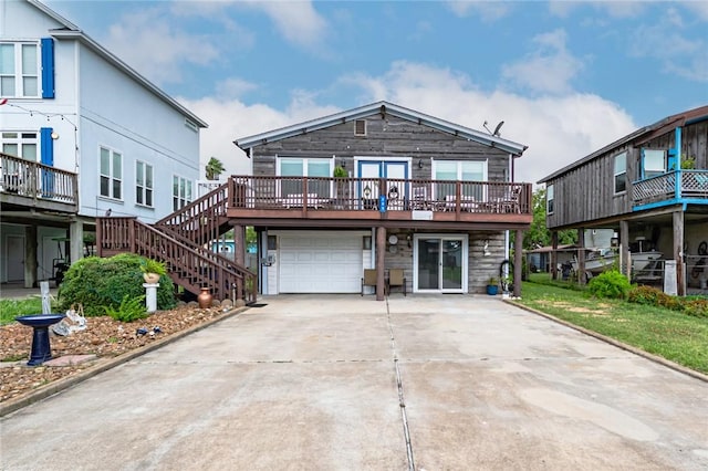 205 S 2nd St, Rockport, TX 78382 - view of front of property with an attached garage, a deck, concrete driveway, and stairway