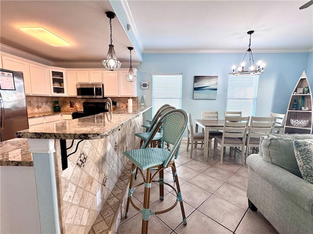 15006 Aruba Dr Unit A, Corpus Christi, TX 78418 - kitchen with a breakfast bar, tasteful backsplash, glass insert cabinets, stainless steel appliances, and white cabinets