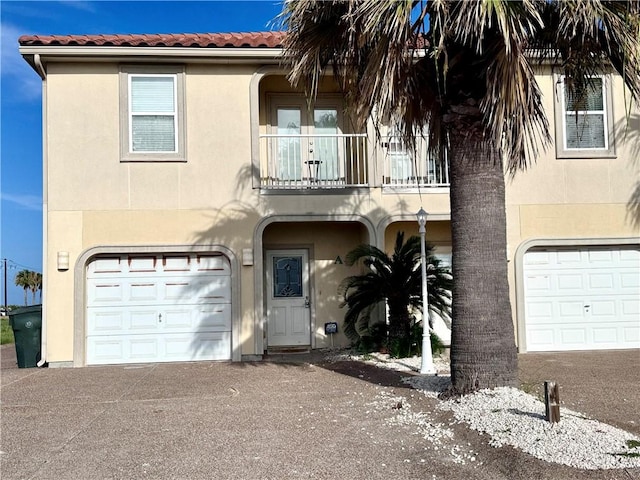 15006 Aruba Dr Unit A, Corpus Christi, TX 78418 - mediterranean / spanish-style house with a balcony, stucco siding, a tiled roof, a garage, and driveway