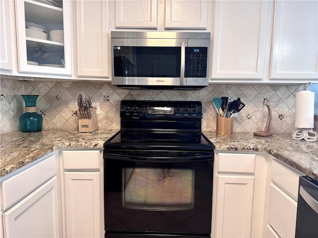 15006 Aruba Dr Unit A, Corpus Christi, TX 78418 - kitchen featuring black electric range oven, stainless steel microwave, white cabinetry, and decorative backsplash