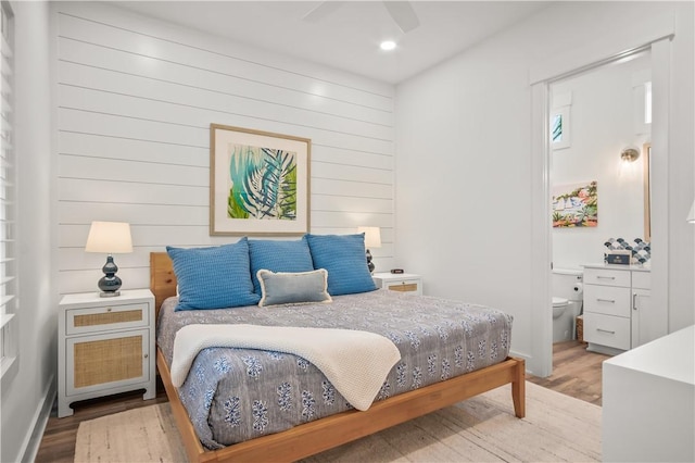 bedroom with ensuite bath and light hardwood / wood-style floors