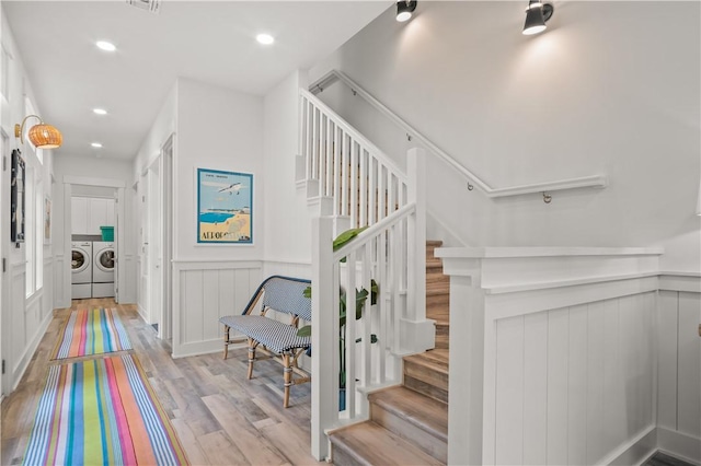 staircase with wood-type flooring and independent washer and dryer