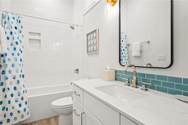 full bathroom featuring hardwood / wood-style floors, backsplash, vanity, shower / tub combo, and toilet