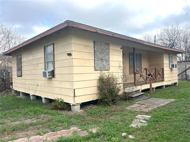 view of side of home featuring cooling unit and a lawn