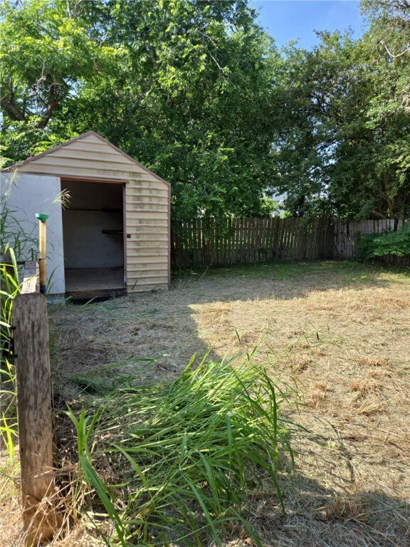 306 S Hall St, Beeville, TX 78102 - view of yard featuring a storage unit, fence, and an outbuilding