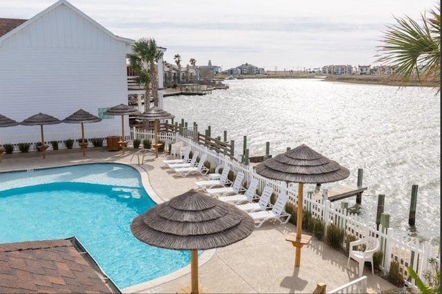 view of swimming pool with a water view and a patio