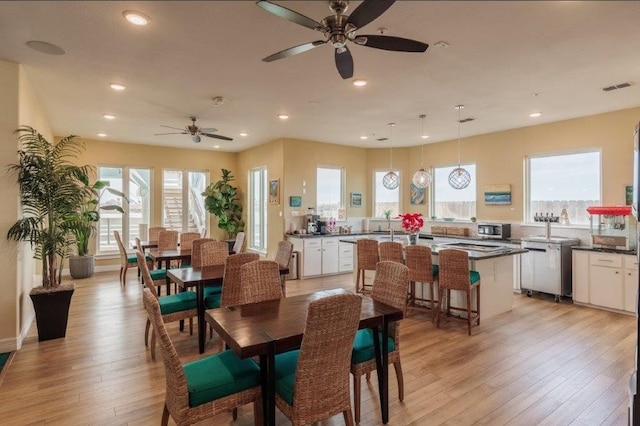 dining space featuring light hardwood / wood-style floors, ceiling fan, and plenty of natural light