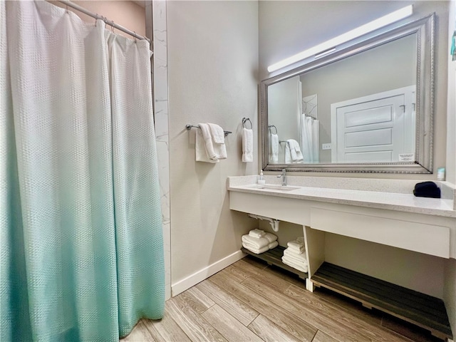 bathroom with hardwood / wood-style flooring, sink, and a shower with curtain