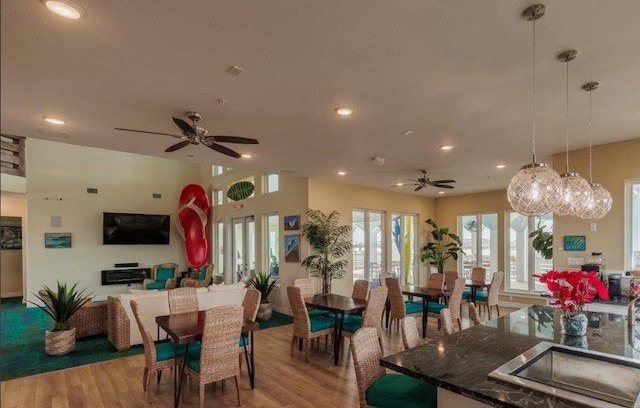 dining room with ceiling fan with notable chandelier and wood-type flooring