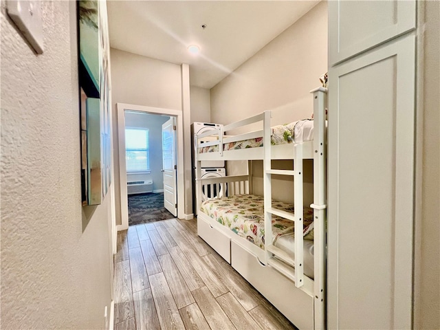 bedroom featuring a wall unit AC and light hardwood / wood-style floors