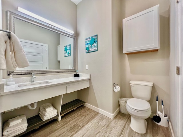 bathroom featuring vanity, hardwood / wood-style flooring, and toilet