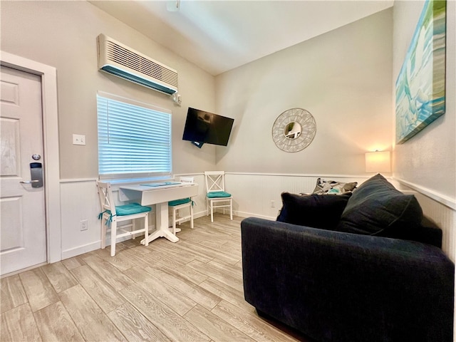 living room featuring light wood-type flooring and a wall mounted AC