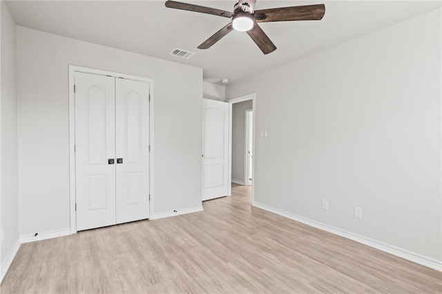 unfurnished bedroom with a ceiling fan, visible vents, baseboards, light wood-style floors, and a closet