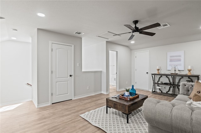 living room featuring light wood-type flooring, visible vents, baseboards, and recessed lighting