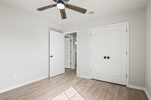 unfurnished bedroom with visible vents, a closet, light wood-style floors, baseboards, and ceiling fan