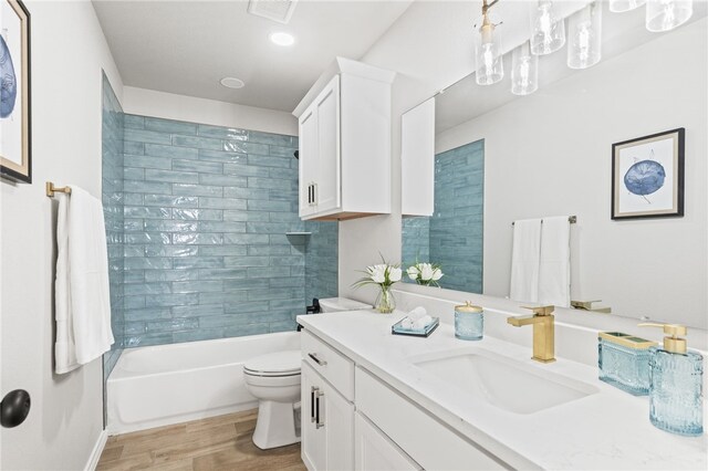 full bathroom featuring visible vents, toilet, wood finished floors, vanity, and  shower combination