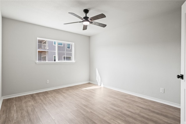 empty room with baseboards, ceiling fan, and wood finished floors