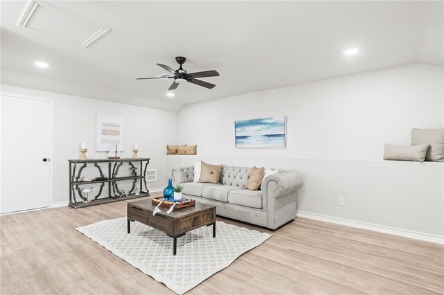 living area featuring light wood-style flooring, attic access, and lofted ceiling