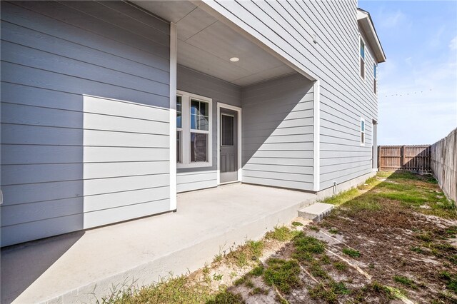 view of exterior entry featuring fence