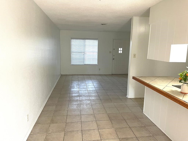 1403 Kingfisher Dr, Beeville, TX 78102 - entryway with light tile patterned floors and a textured ceiling
