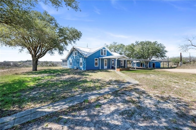 view of front of property featuring a front yard and metal roof