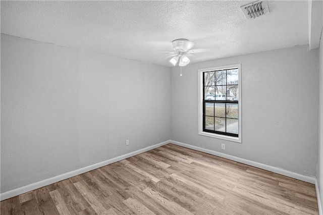 unfurnished room with ceiling fan, a textured ceiling, and light wood-type flooring