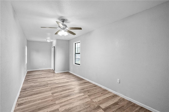 unfurnished room with ceiling fan, light hardwood / wood-style floors, and a textured ceiling