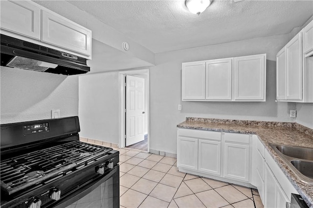 kitchen featuring white cabinetry, sink, light tile patterned floors, black gas stove, and a textured ceiling