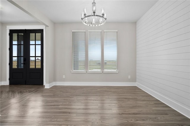 interior space with a chandelier, french doors, dark hardwood / wood-style flooring, and a wealth of natural light