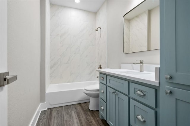 full bathroom with tiled shower / bath combo, toilet, wood-type flooring, and vanity