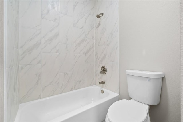 bathroom with toilet and tiled shower / bath